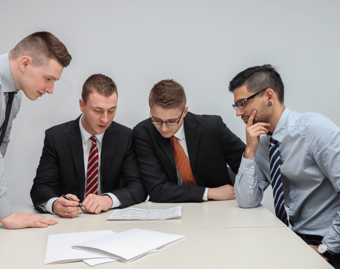 Grupo estudiando un papel bien vestidos